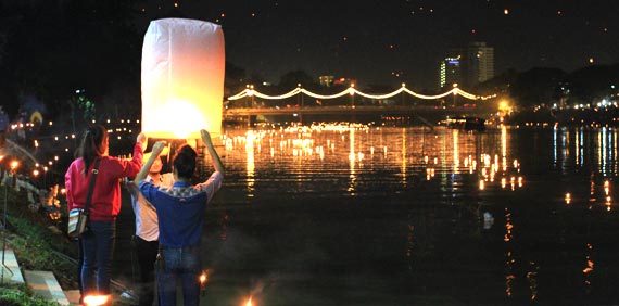 Tailandeses haciendo ofrendas en el río. Chiang Mai